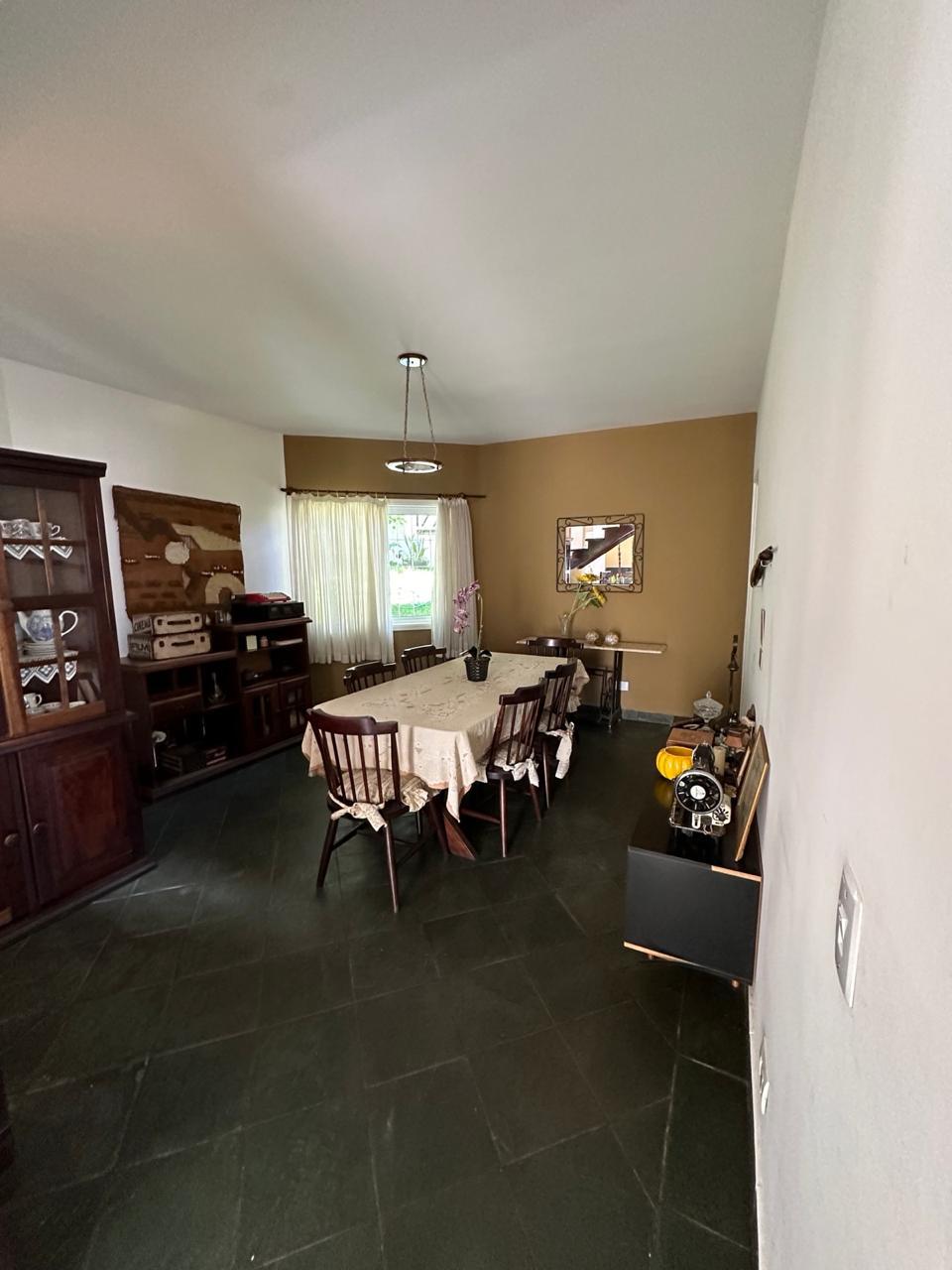 Sala de jantar com mesa, cadeiras e mobiliário de madeira