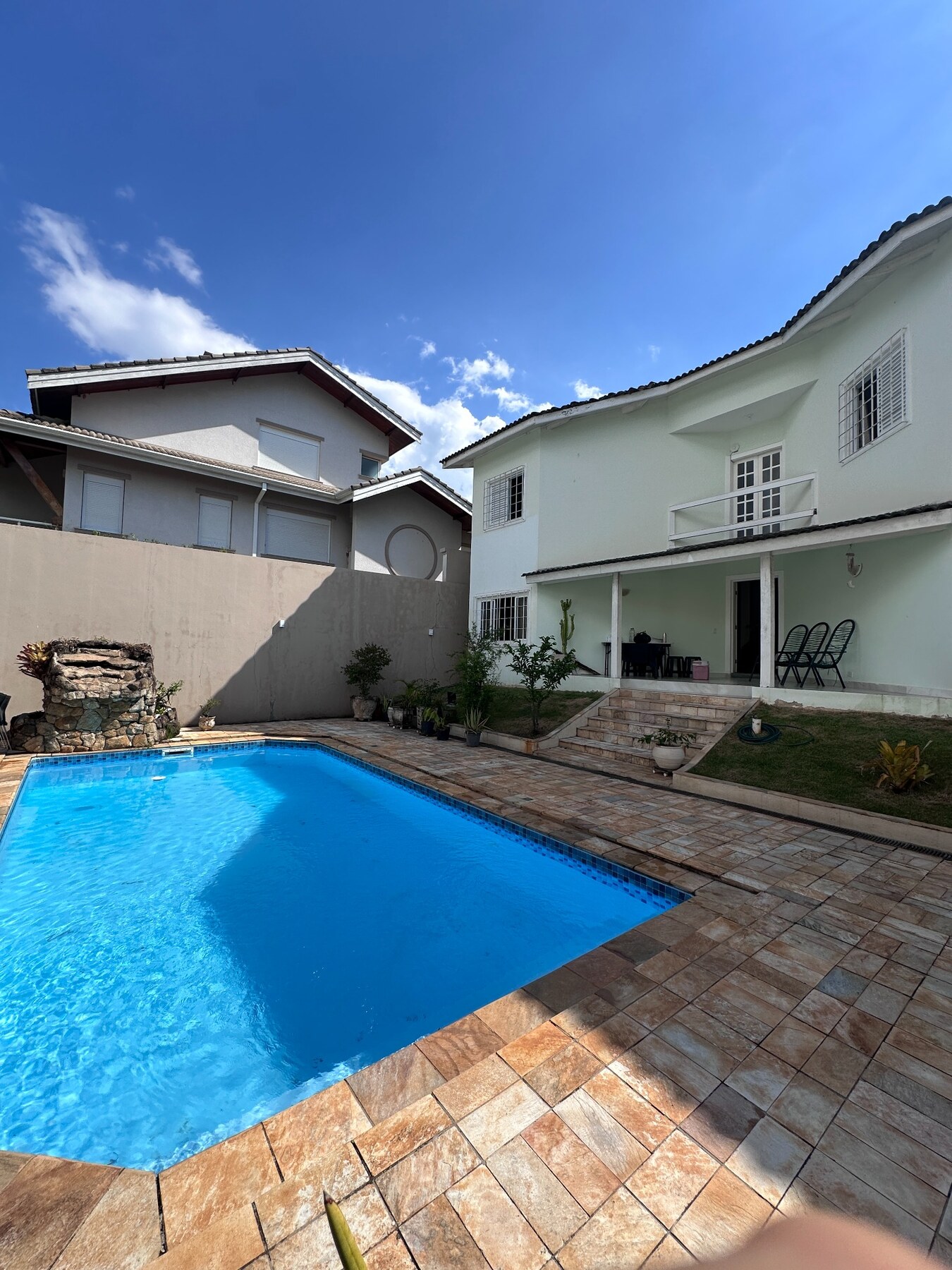 Piscina e fachada em um dia de sol